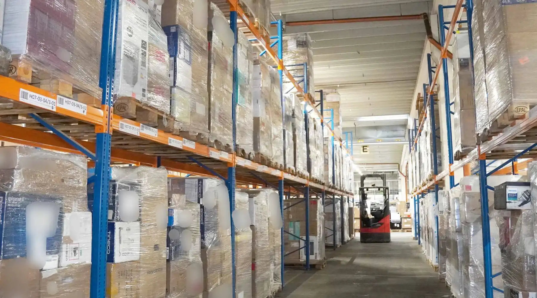 Hochregale voll palettierter Restpostenware in einem modernen Lager – ideal für den Handel mit Restposten – professionell, profitabel und planbar.